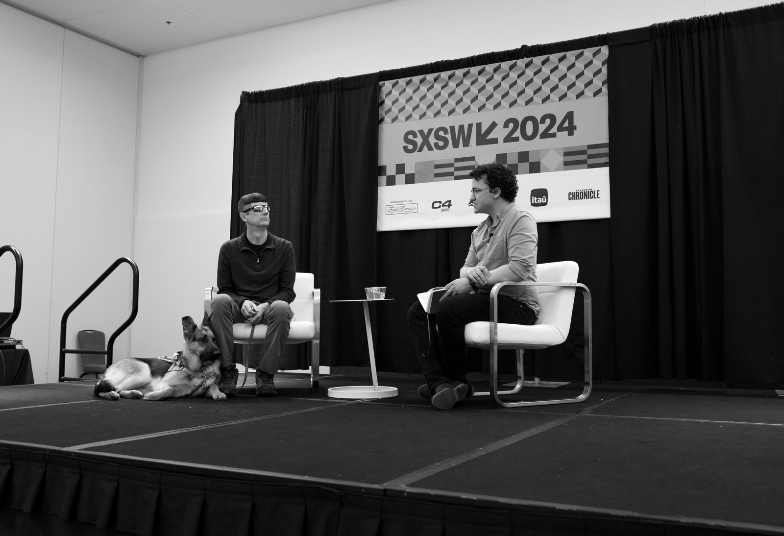 Jimmy Fremgen moderating a panel at SXSW 2024 with Ed Summers, GitHub, and his service dog Loki